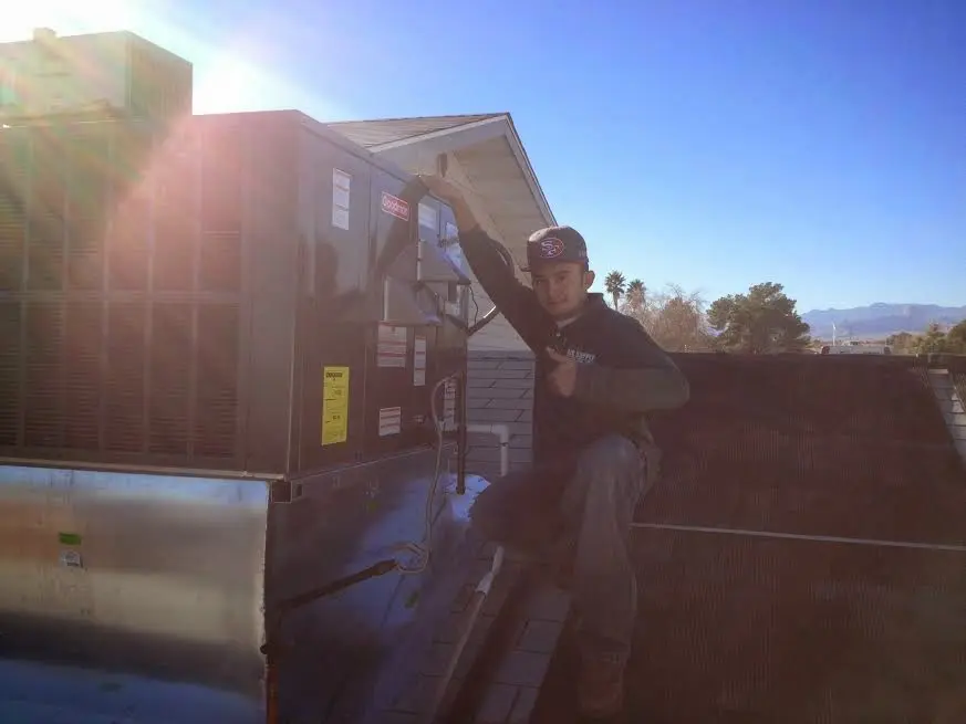 HVAC technician performing HVAC Inspection on a rooftop unit in Athens
